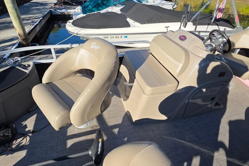 Slide: The Image of 2023 Ranger Reata 200F boat interior with beige seating and steering console. - 11