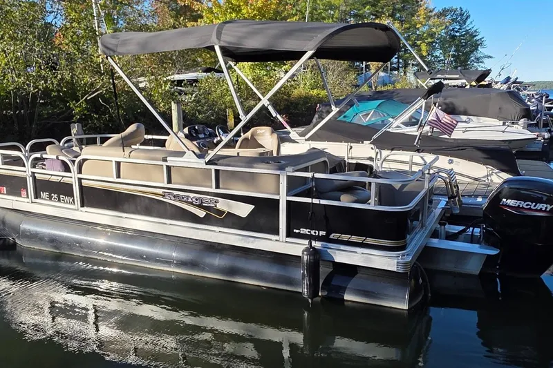 Slide: The Image of 2023 Ranger Reata 200F pontoon boat docked, featuring a canopy and Mercury outboard motor. - 13