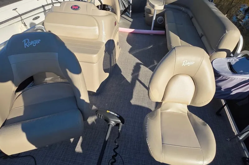 Slide: The Image of 2023 Ranger Reata 200F boat interior with beige seating and steering console. - 7