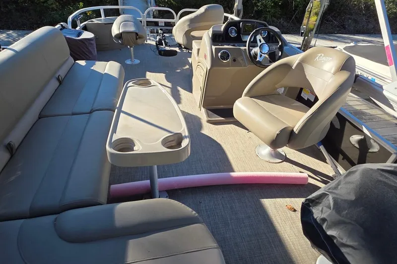 Slide: The Image of 2023 Ranger Reata 200F boat interior with beige seating and steering console. - 8