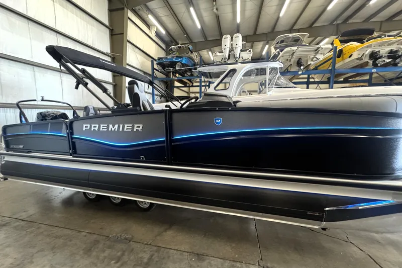 Slide: The Image of 2026 Premier 230 SOLARIS RS pontoon boat in a showroom, featuring sleek design and modern lighting. - 12