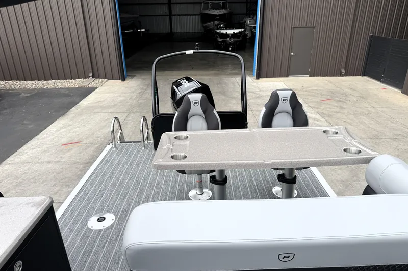 Slide: The Image of 2026 Premier 230 SOLARIS RS boat interior with seating and table, docked in a warehouse. - 30