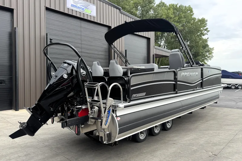 Slide: The Image of 2026 Premier 230 SOLARIS RS pontoon boat with outboard motor, parked outside a marine facility. - 6