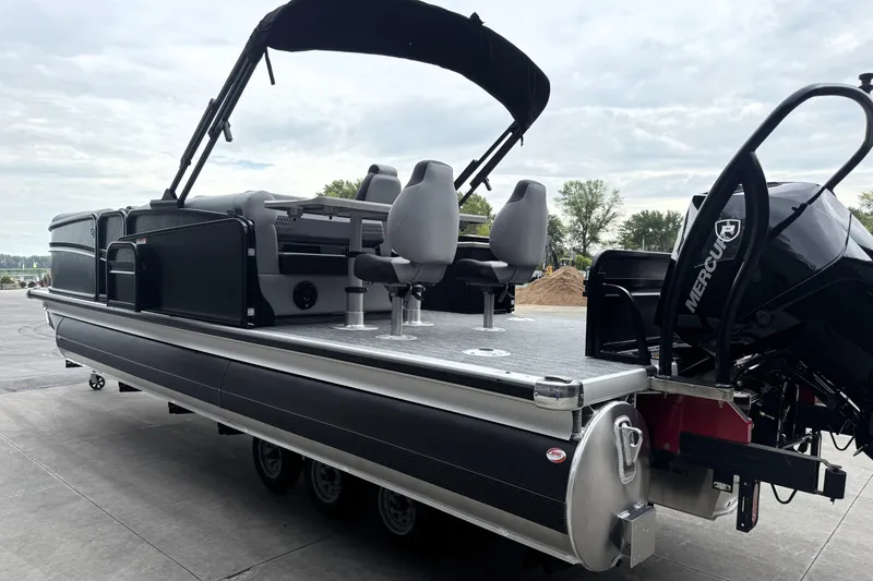 Slide: The Image of 2026 Premier 230 Solaris RS pontoon boat with Mercury engine, docked under cloudy sky. - 8
