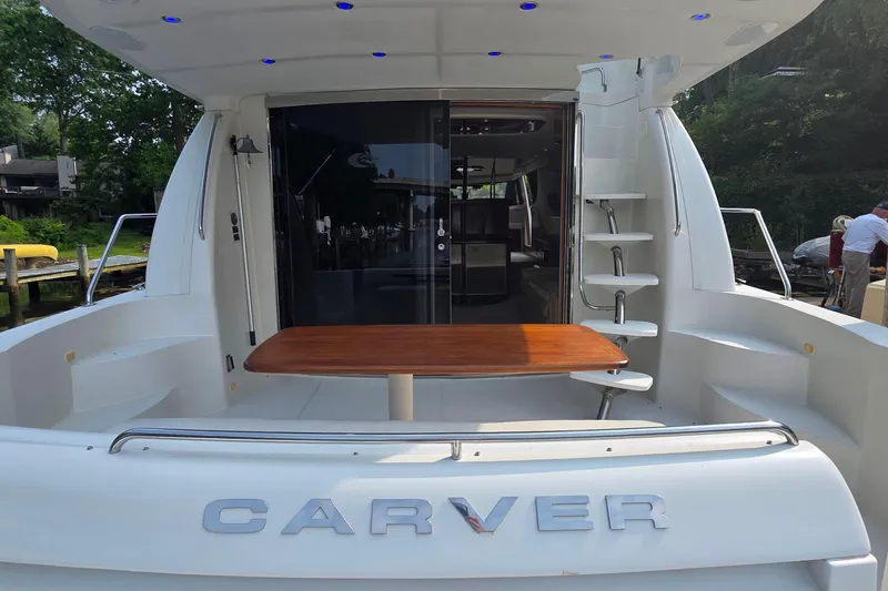 Slide: The Image of 2006 Carver 56 Voyager yacht stern with table, steps, and sliding glass doors. - 11