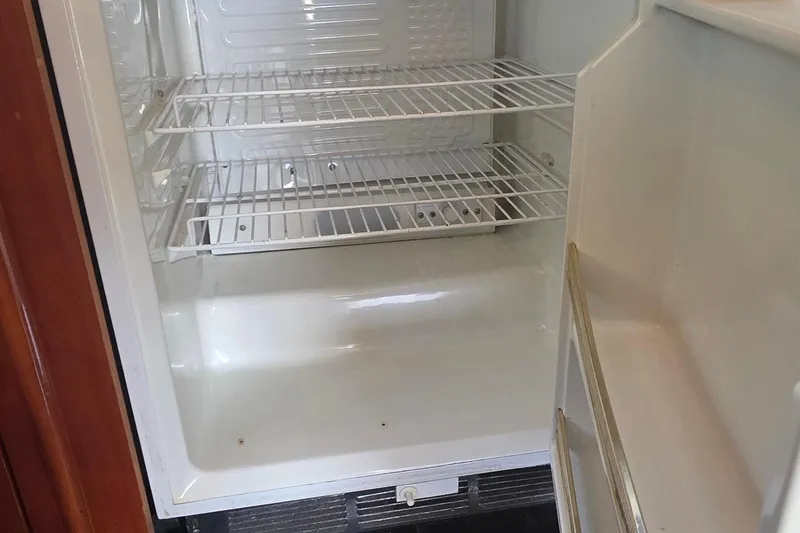 Slide: The Image of Empty refrigerator inside a 2006 Carver 56 Voyager yacht, featuring wire shelves. - 17
