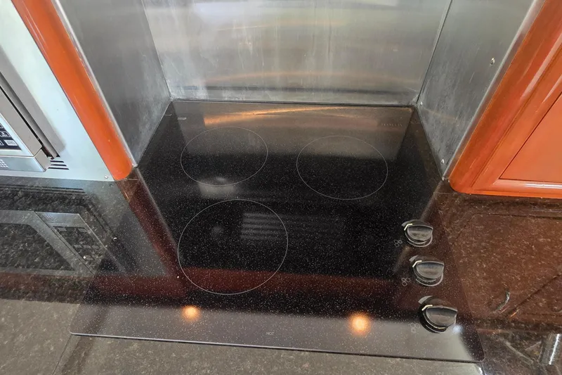 Slide: The Image of Stovetop in 2006 Carver 56 Voyager yacht kitchen with sleek black finish. - 19