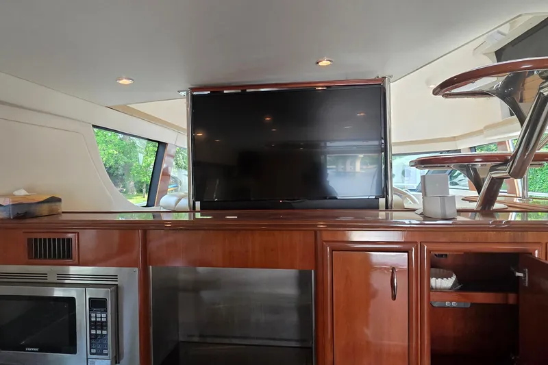 Slide: The Image of Interior of 2006 Carver 56 Voyager yacht with TV, microwave, and wooden cabinetry. - 21