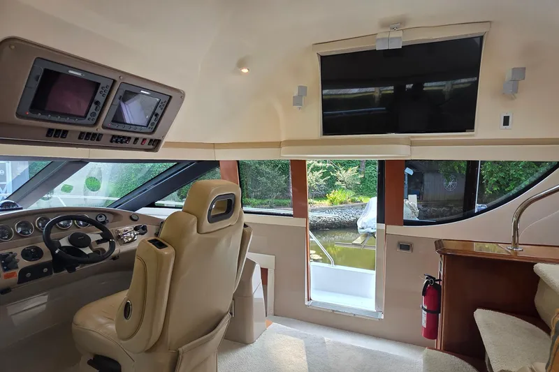 Slide: The Image of Interior of a 2006 Carver 56 Voyager yacht with helm, navigation screens, and luxurious seating. - 28
