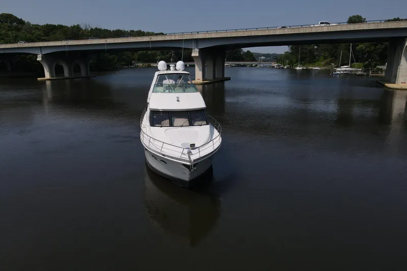 Slide: The Image of 2006 Carver 56 Voyager yacht on calm river under bridge. - 3