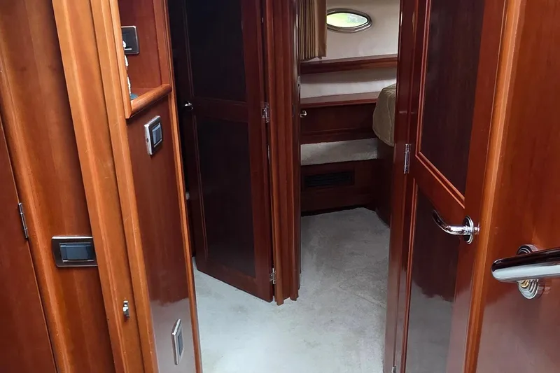 Slide: The Image of Interior of 2006 Carver 56 Voyager yacht, featuring polished wood doors and cozy cabin space. - 32