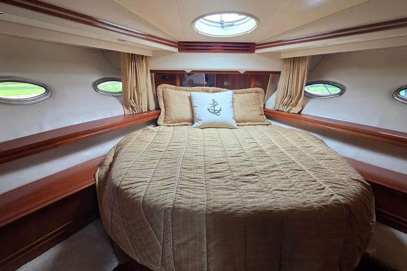 Slide: The Image of Luxurious bedroom interior of 2006 Carver 56 Voyager yacht with elegant bedding and porthole windows. - 33