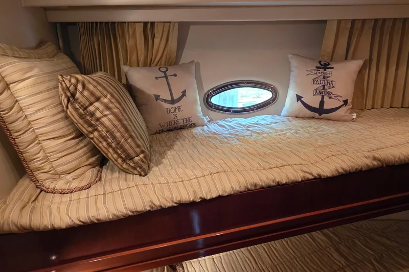 Slide: The Image of Cozy cabin interior of 2006 Carver 56 Voyager with nautical-themed pillows and porthole window. - 39