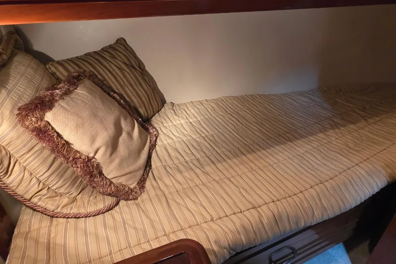 Slide: The Image of Cozy cabin bed in 2006 Carver 56 Voyager yacht with striped bedding and decorative pillow. - 40