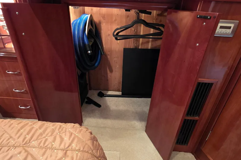Slide: The Image of Open closet in 2006 Carver 56 Voyager yacht with hangers and vacuum hose. - 50