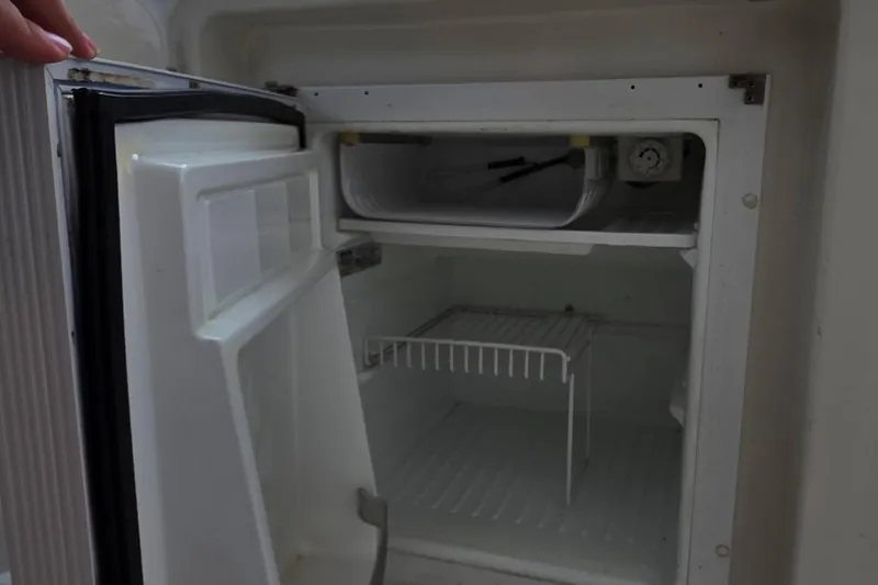 Slide: The Image of Open refrigerator inside a 2006 Carver 56 Voyager yacht, showing empty shelves. - 62