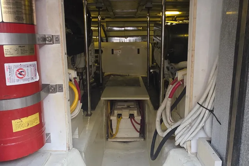 Slide: The Image of Engine room of a 2006 Carver 56 Voyager yacht with visible fire extinguisher and cables. - 72