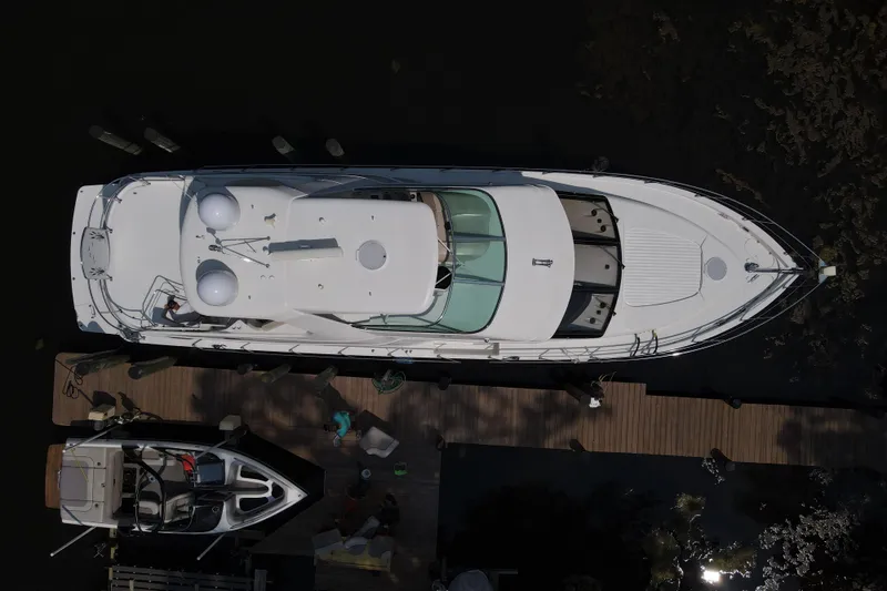 Slide: The Image of Aerial view of a 2006 Carver 56 Voyager yacht docked at a wooden pier. - 77
