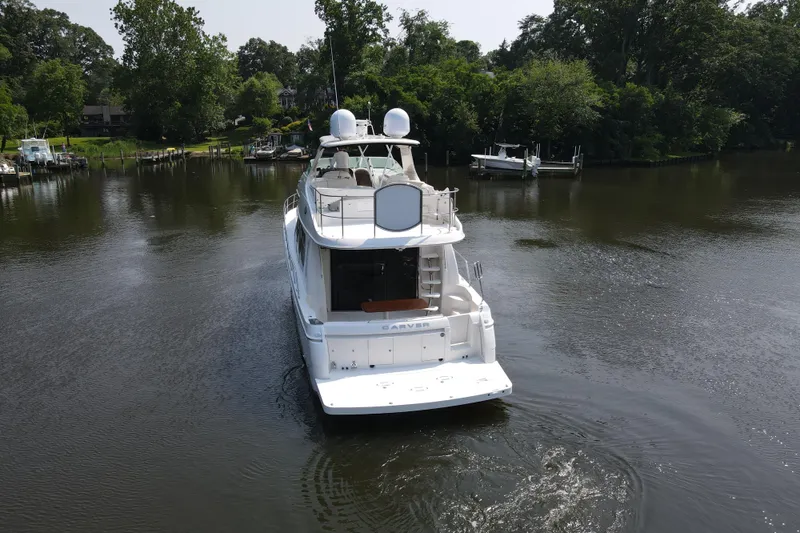 Slide: The Image of 2006 Carver 56 Voyager yacht cruising on a serene river surrounded by lush greenery. - 8