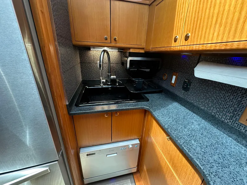 Slide: The Image of Compact kitchen in 2005 Jefferson Rivanna 50 SDMY yacht with modern appliances and wood cabinetry. - 39