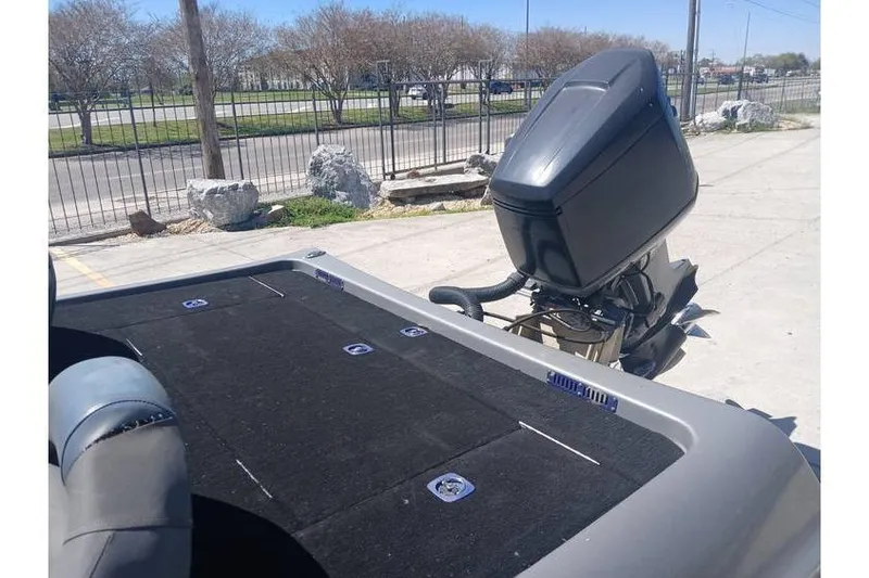 Slide: The Image of 1994 Gambler 21 boat with outboard motor, parked outdoors on a sunny day. - 10