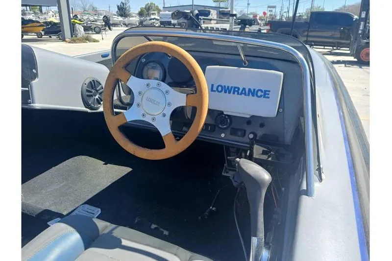 Slide: The Image of 1994 Gambler 21 boat cockpit with wooden steering wheel and Lowrance navigation system. - 11