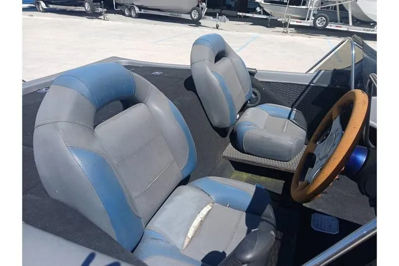 Slide: The Image of Interior of a 1994 Gambler 21 boat with blue and gray seats. - 13