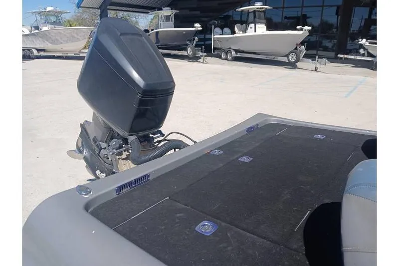 Slide: The Image of 1994 Gambler 21 boat with outboard motor, parked near other boats in a marina. - 14