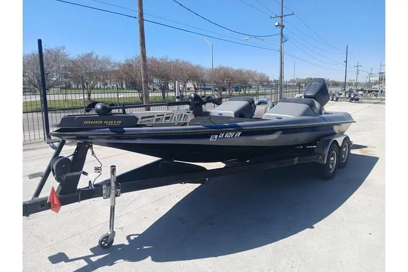 Slide: The Image of 1994 Gambler 21 boat on trailer, parked outdoors under clear blue sky. - 4