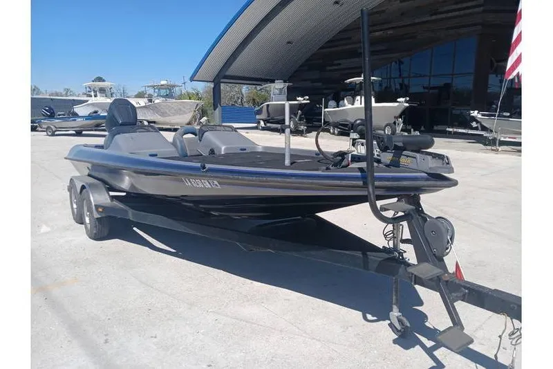 Slide: The Image of 1994 Gambler 21 boat on trailer, parked outdoors near other boats. - 5