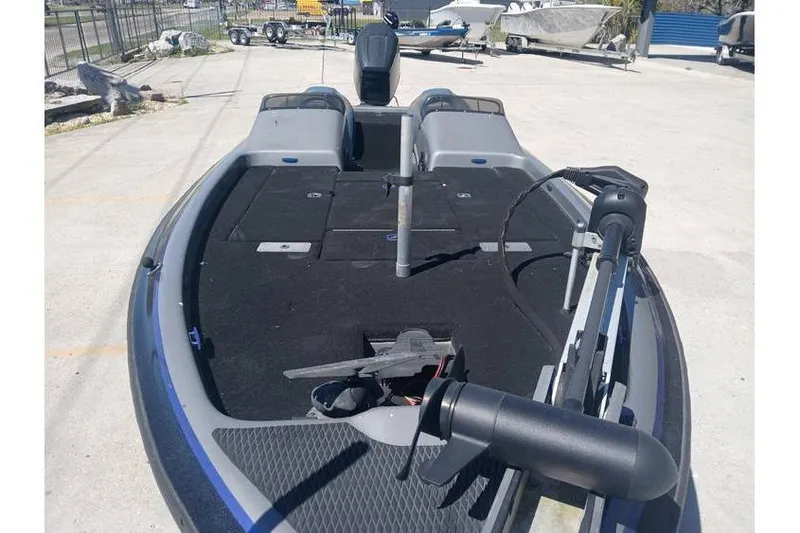 Slide: The Image of 1994 Gambler 21 boat with black deck, parked outdoors, surrounded by other boats. - 6