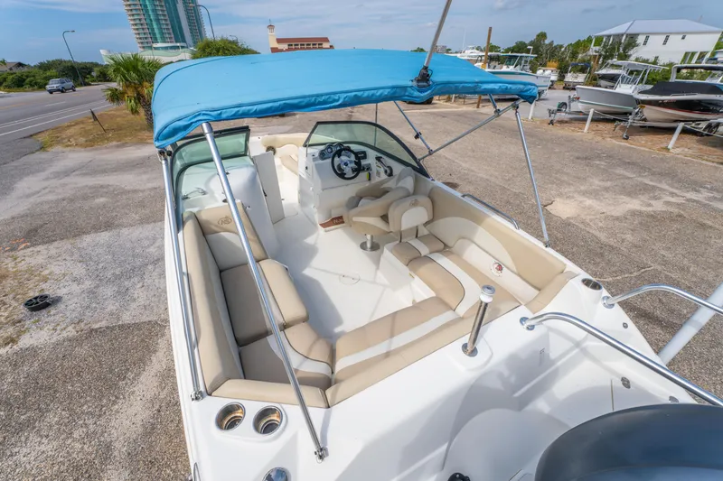 Slide: The Image of 2017 NauticStar 223DC Sport Deck boat with blue canopy and spacious seating. - 11