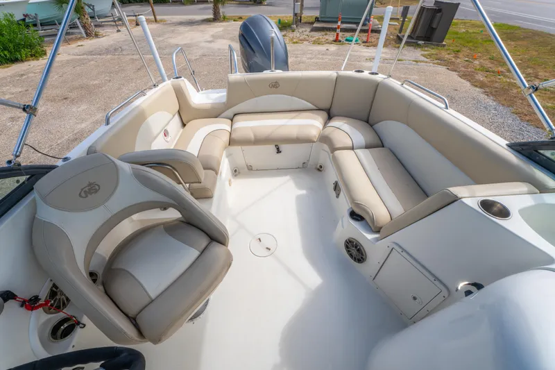 Slide: The Image of 2017 NauticStar 223DC Sport Deck boat interior with beige seating and steering wheel. - 12