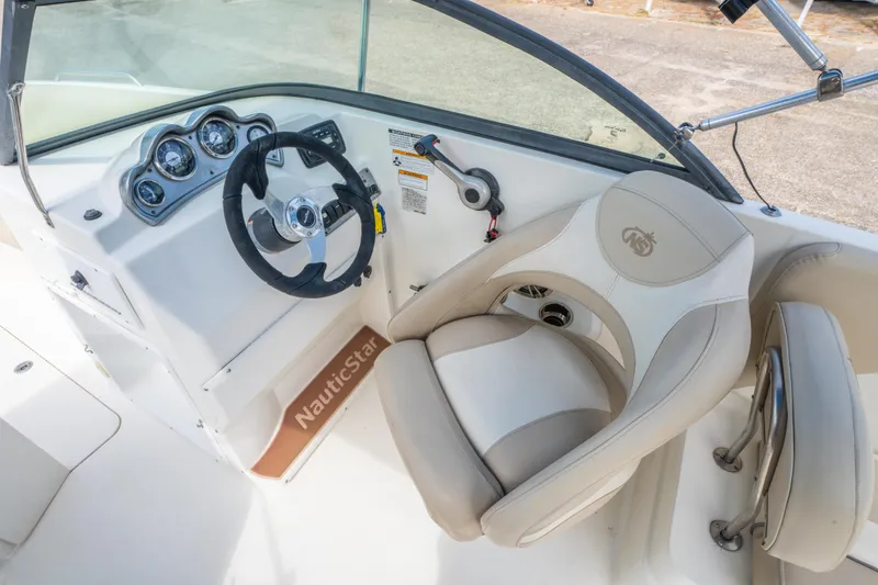 Slide: The Image of 2017 NauticStar 223DC Sport Deck boat interior with steering wheel and captain's seat. - 15