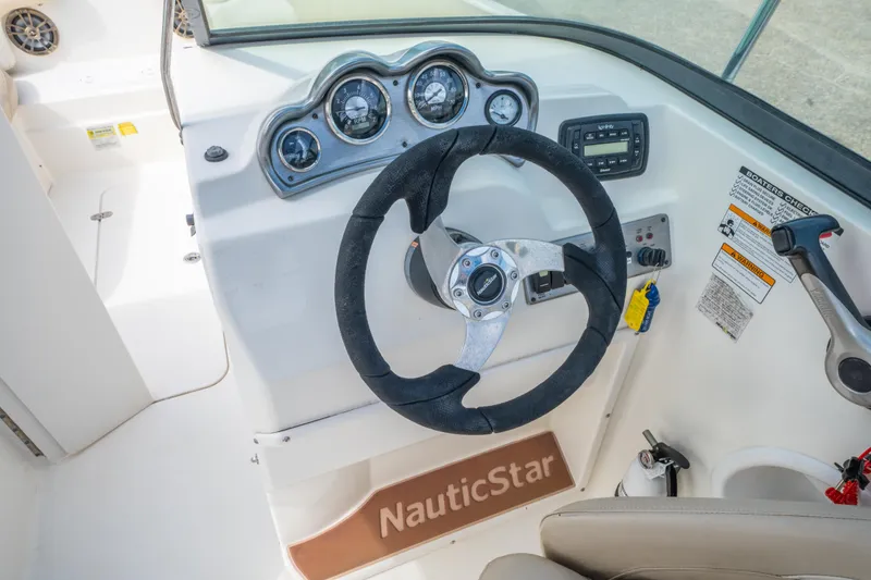 Slide: The Image of Steering console of 2017 NauticStar 223DC Sport Deck boat with gauges and controls. - 16