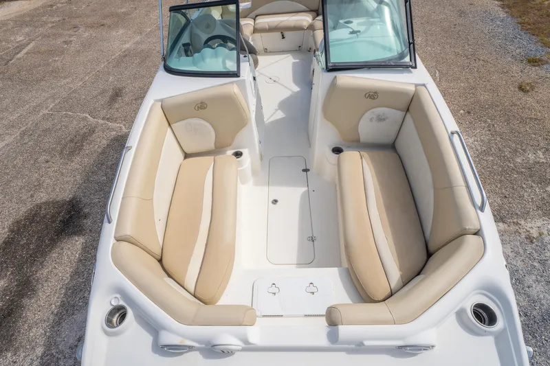 Slide: The Image of 2017 NauticStar 223DC Sport Deck boat with beige seating and open deck layout. - 20