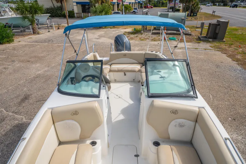 Slide: The Image of 2017 NauticStar 223DC Sport Deck boat with blue canopy and beige seating. - 21