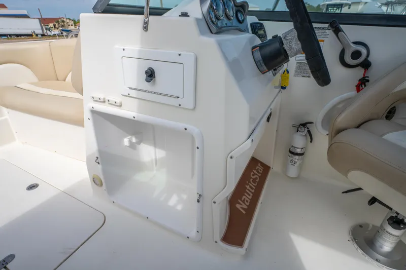 Slide: The Image of 2017 NauticStar 223DC Sport Deck interior with steering wheel and seating. - 22