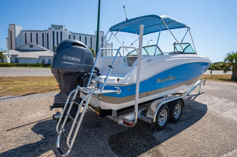 Slide: The Image of 2017 NauticStar 223DC Sport Deck boat with Yamaha engine on trailer, parked outdoors. - 3