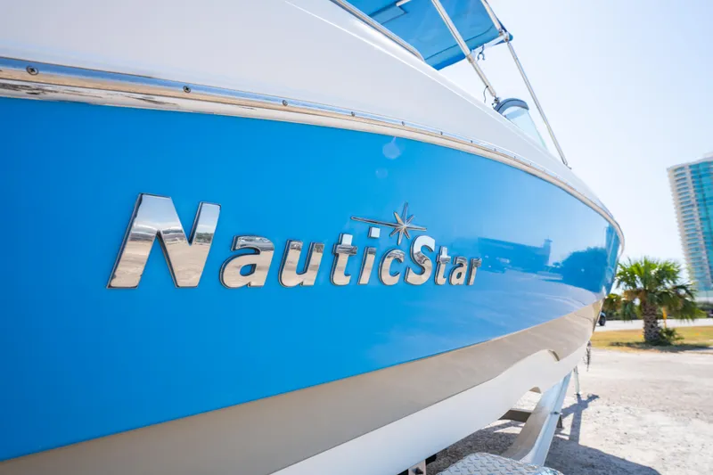 Slide: The Image of 2017 NauticStar 223DC Sport Deck boat with blue hull, parked outdoors. - 7