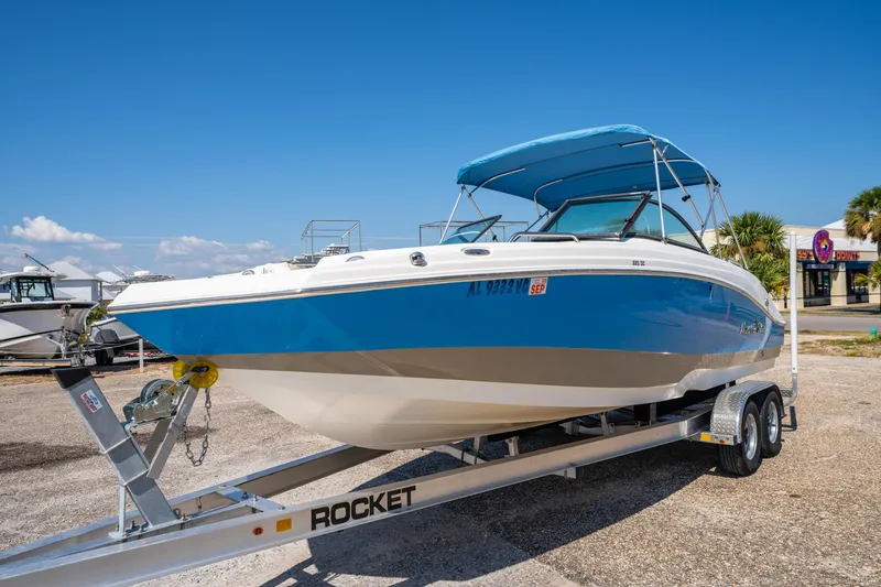 Slide: The Image of 2017 NauticStar 223DC Sport Deck boat on trailer, blue and white, sunny day. - 8