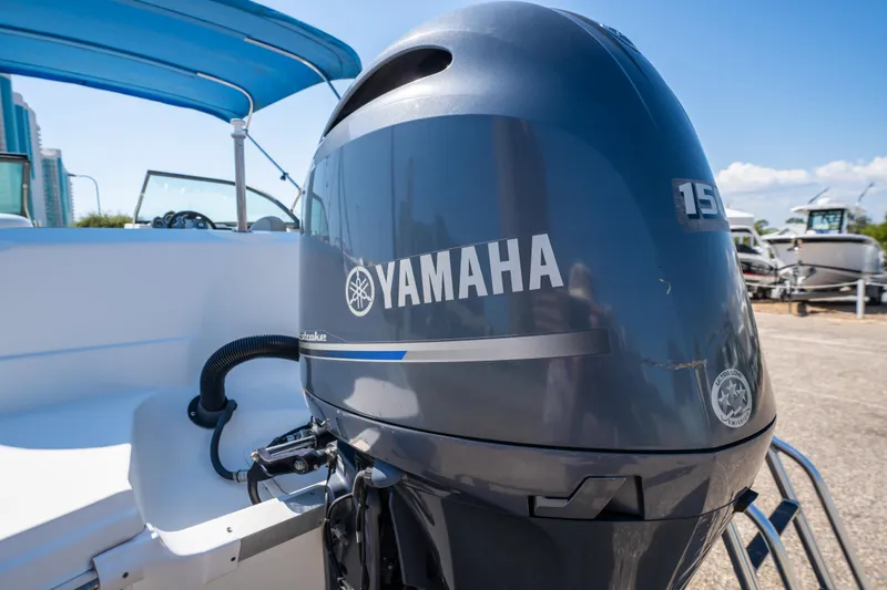 Slide: The Image of 2017 NauticStar 223DC Sport Deck with Yamaha 150 outboard motor, blue canopy, and white interior. - 9