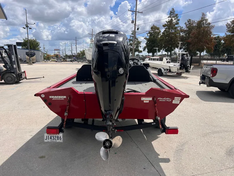 Slide: The Image of 2024 Tracker Pro Team 175 boat with Mercury engine, parked outdoors on a sunny day. - 3