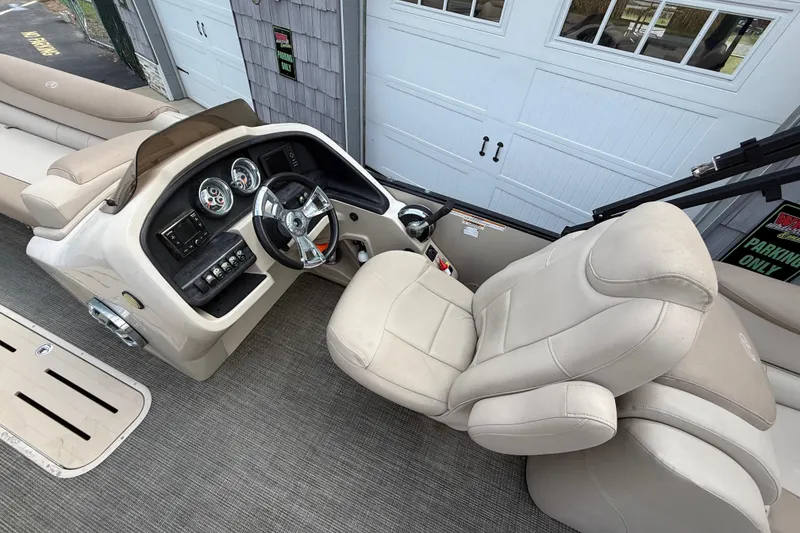 Slide: The Image of 2018 Avalon 2585 Catalina Elite Tri-toon boat interior with steering console and seating. - 19