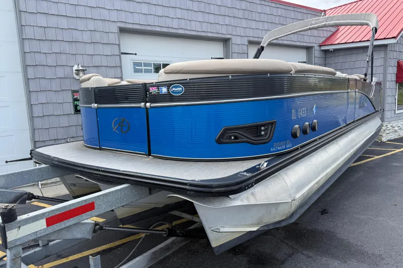 Slide: The Image of 2018 Avalon 2585 Catalina Elite Tri-toon boat on trailer, blue exterior, parked outside. - 4