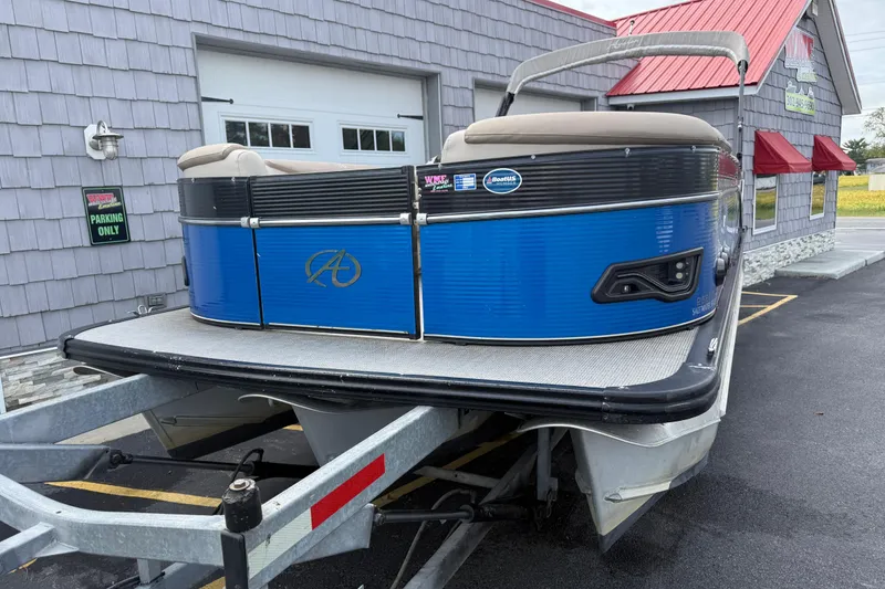 Slide: The Image of 2018 Avalon 2585 Catalina Elite Tri-toon boat on trailer, parked outside a building. - 5