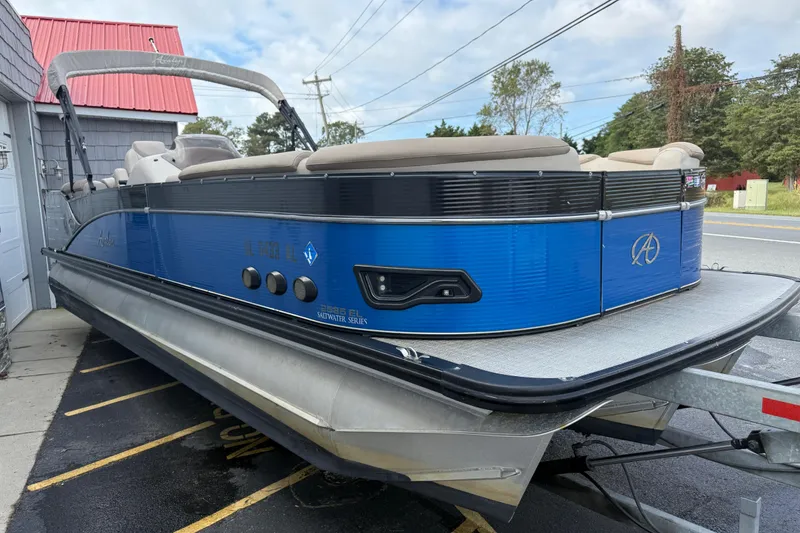Slide: The Image of 2018 Avalon 2585 Catalina Elite Tri-toon boat on trailer, blue exterior, parked outdoors. - 8