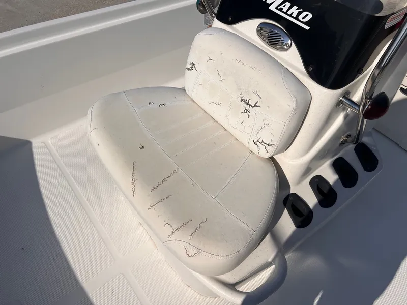 Slide: The Image of 2016 Mako Pro 17 Skiff CC boat seat with visible wear and cracks. - 11