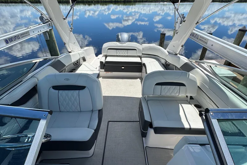 Slide: The Image of 2021 Regal 26 OBX boat interior with luxurious seating and scenic water reflection. - 10