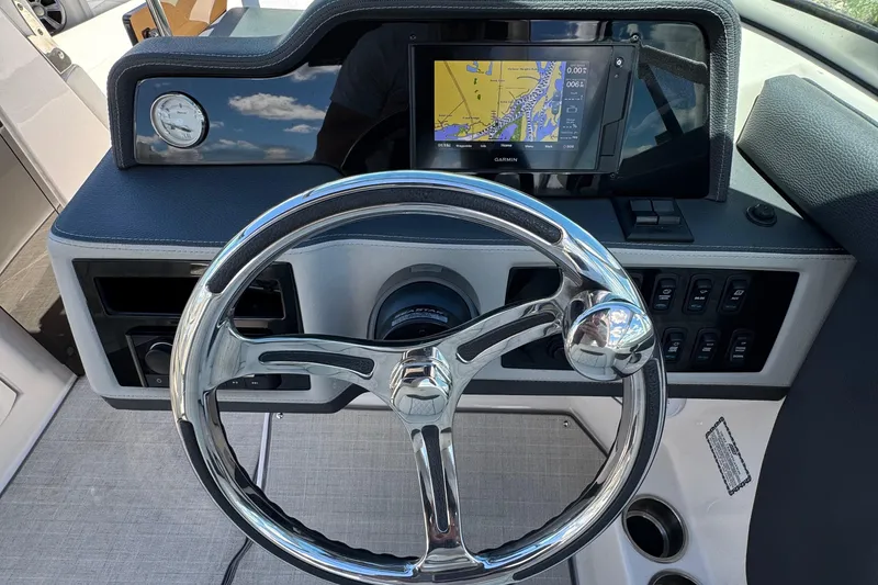 Slide: The Image of 2021 Regal 26 OBX boat dashboard with steering wheel and navigation display. - 13